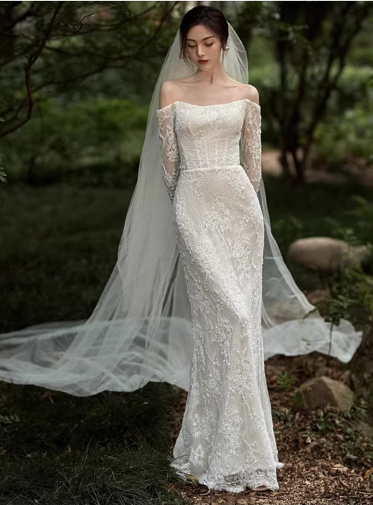 Robe de mariée sirène élégante en dentelle ivoire, épaules dénudées, manches longues et traîne avec voile DP7686