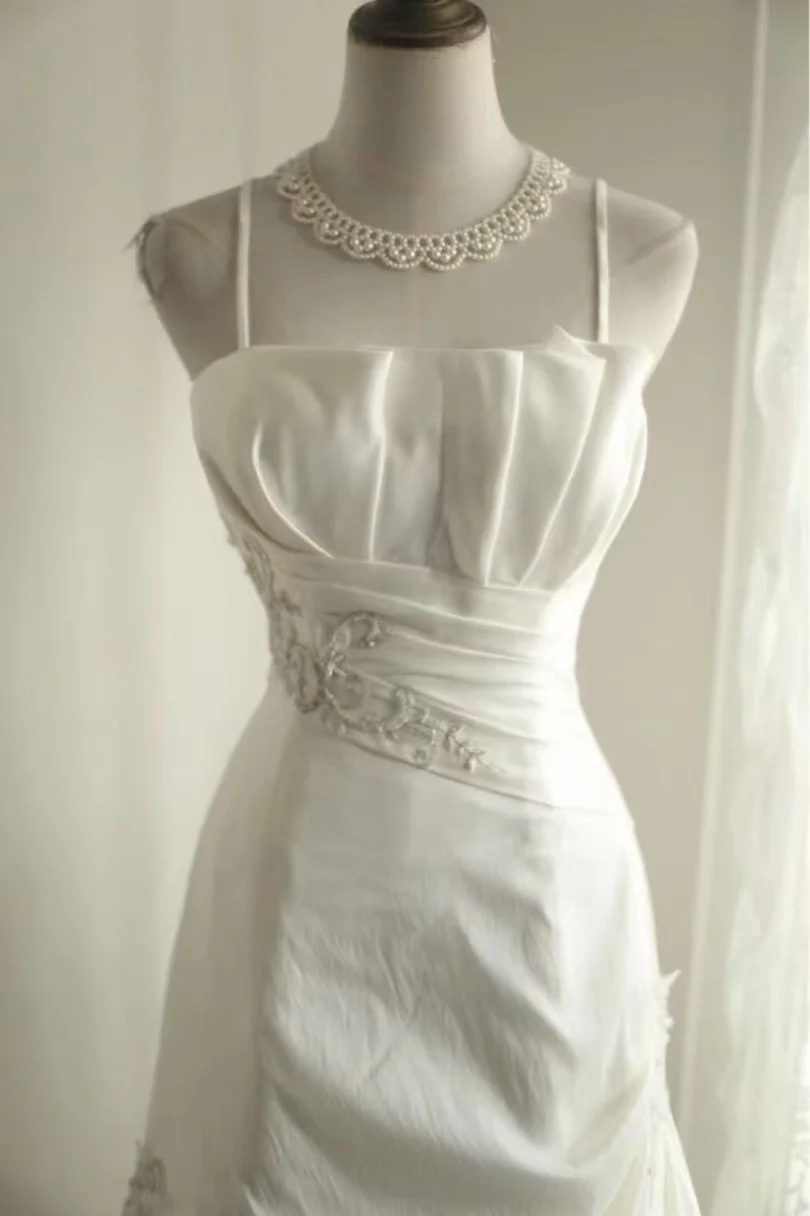Robe de mariée vintage blanche en satin à fines bretelles, broderies et corsage froncé, coupe trapèze DP7641